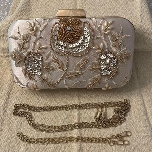 Elegant embroidered evening bag with gold tones and cream colored satin.